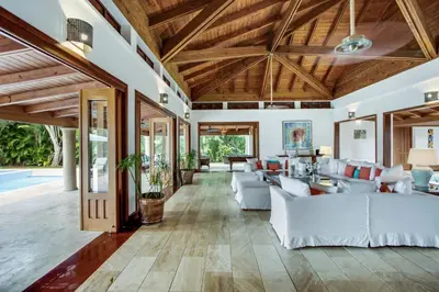 an open living room with white furniture and wooden ceilings at Gorgeous villa at Casa de Campo - with large pool, cook, maid and 2 golf carts in La Romana