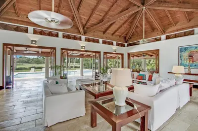a living room with white furniture and a wooden ceiling at Gorgeous villa at Casa de Campo - with large pool, cook, maid and 2 golf carts in La Romana