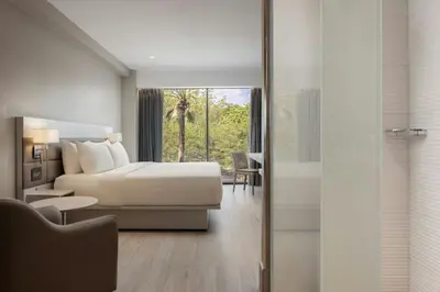 a hotel room with a bed and a sliding glass door at AC Hotel by Marriott Santiago de los Caballeros in Santiago de los Caballeros