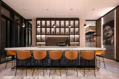 a bar in a restaurant with orange chairs at AC Hotel by Marriott Santiago de los Caballeros in Santiago de los Caballeros