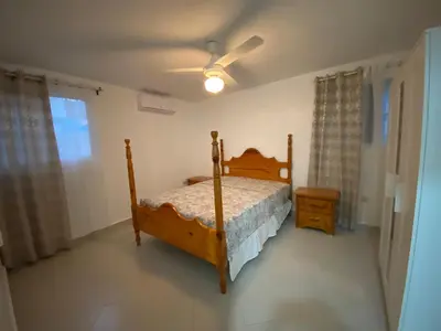 a bedroom with a bed and a ceiling fan at 1BR Suite at Villa Costa Verde near Playa Cofresi, Puerto Plata, with a pool, balcony and a rooftop terrace in San Felipe de Puerto Plata
