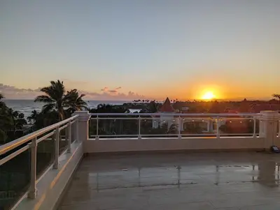 a view of the sunset from the balcony of a hotel at 1BR Suite at Villa Costa Verde near Playa Cofresi, Puerto Plata, with a pool, balcony and a rooftop terrace in San Felipe de Puerto Plata