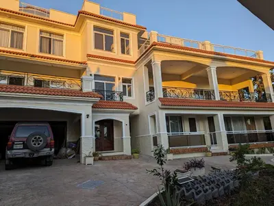 a car parked in front of a large building at 1BR Suite at Villa Costa Verde near Playa Cofresi, Puerto Plata, with a pool, balcony and a rooftop terrace in San Felipe de Puerto Plata