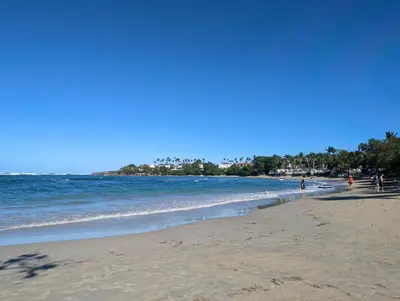 a group of people walking on the beach at 1BR Suite at Villa Costa Verde near Playa Cofresi, Puerto Plata, with a pool, balcony and a rooftop terrace in San Felipe de Puerto Plata