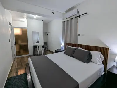 a bedroom with a large bed with white sheets and pillows at A 7 minutos del Aeropuerto SDQ, Moderno y Compacto Apartamento in Boca Chica