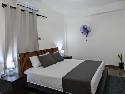 a bedroom with a bed and a blue fan at A 7 minutos del Aeropuerto SDQ, Moderno y Compacto Apartamento in Boca Chica