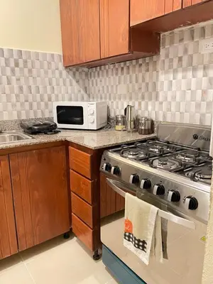 a kitchen with a stove and a microwave at Posada del caribe in La Cana