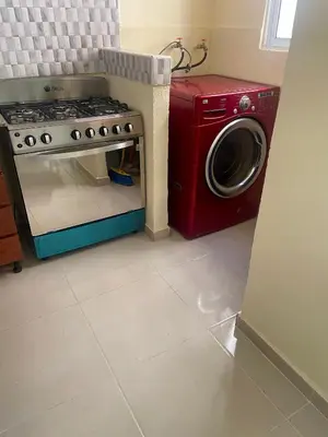 a kitchen with a stove and a washing machine at Posada del caribe in La Cana