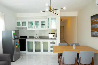 a kitchen with a table and a refrigerator at Apartahotel Señorial in Higuey