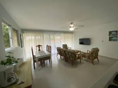 a kitchen and dining room with a table and chairs at 2 BR & 1WR Suite at Villa Costa Verde near Playa Cofresi, Puerto Plata with a pool, balcony, and a rooftop terrace in San Felipe de Puerto Plata