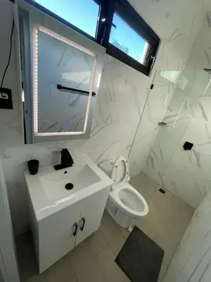 a white bathroom with a sink and a toilet at LEVEL suites #7 in Sosúa