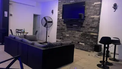 a living room with a couch and a tv on a brick wall at LEVEL suites #7 in Sosúa
