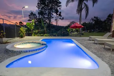 a blue swimming pool in a yard with a table at The American Dream in Jarabacoa