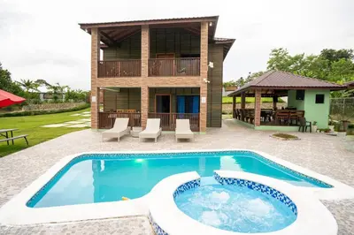 a villa with a swimming pool and a house at The American Dream in Jarabacoa