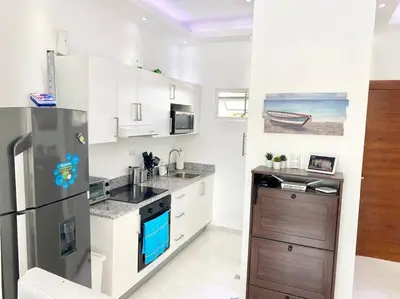 a kitchen with a stainless steel refrigerator and a sink at Beautiful and peaceful 2-bedroom family condo in Juan Dolio