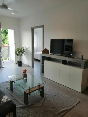 a living room with a tv and a coffee table at Sabrina Plaza Residence in Las Terrenas