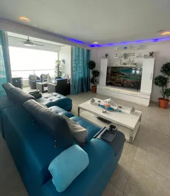 a living room with a blue couch and a table at Beachfront Apartment with Jacuzzi in Juan Pedro