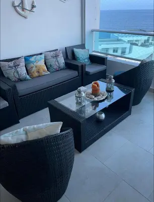 a living room with wicker chairs and a table at Beachfront Apartment with Jacuzzi in Juan Pedro