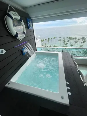 a jacuzzi tub in a balcony with a clock at Beachfront Apartment with Jacuzzi in Juan Pedro