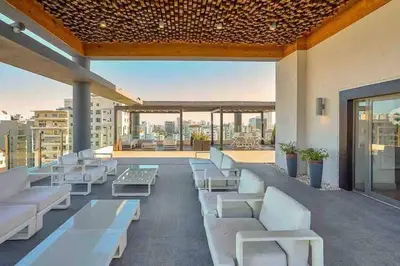 a patio with white couches and tables on a building at Dream Rooftop Downtown View in Santo Domingo