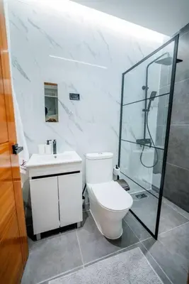 a bathroom with a toilet and a shower and a sink at Villa Hermosa en Metro Country Club Juan Dolio in Juan Dolio