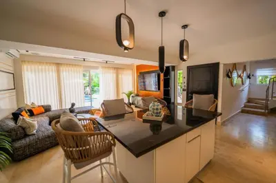 a kitchen and living room with a couch and a table at Villa Hermosa en Metro Country Club Juan Dolio in Juan Dolio