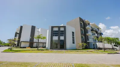 a building with two tall buildings in a parking lot at 1BDR Rockstar's Paradise in front of Hard Rock H. in Punta Cana