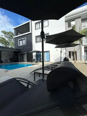 a building with a pool and umbrellas and a swimming pool at LEVEL suites premium in Sosúa