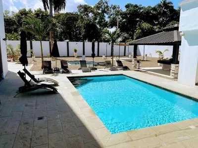 a swimming pool with chairs next to a fence at LEVEL suites premium in Sosúa