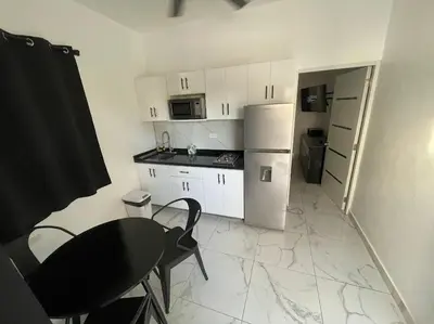a small kitchen with a table and a refrigerator at LEVEL suites #8 in Sosúa
