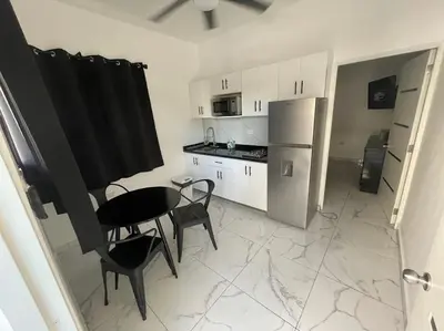 a kitchen with a table and chairs and a refrigerator at LEVEL suites #8 in Sosúa