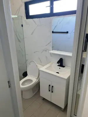 a bathroom with a toilet and a sink and a window at LEVEL suites #8 in Sosúa