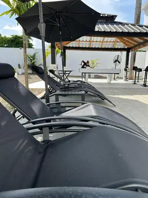 a group of chairs and a table with an umbrella at LEVEL suites #8 in Sosúa