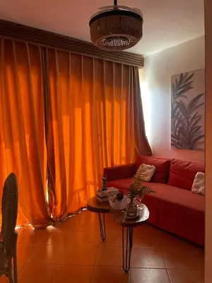 a living room with a red couch and an orange curtain at Estancia Nana Tu Refugio con Vista al Mar, Piscina, wifi, lavadora secadora Reserva Ahora in Juan Dolio