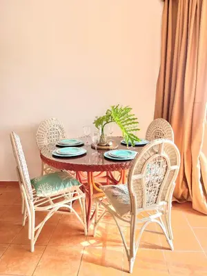 a dining room table with four chairs and a table with a plant at Estancia Nana Tu Refugio con Vista al Mar, Piscina, wifi, lavadora secadora Reserva Ahora in Juan Dolio