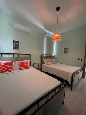 a bedroom with two beds and a light fixture at Casa Monte Verde in Las Galeras