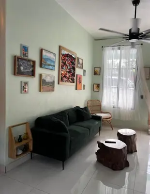 a living room with a green couch and a ceiling fan at Casa Monte Verde in Las Galeras