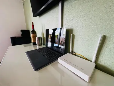 a laptop computer sitting on a table with a bottle of wine at Vista Bayahibe Paradise in Bayahibe