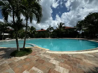 a swimming pool with a palm tree next to it at Vista Bayahibe Paradise in Bayahibe