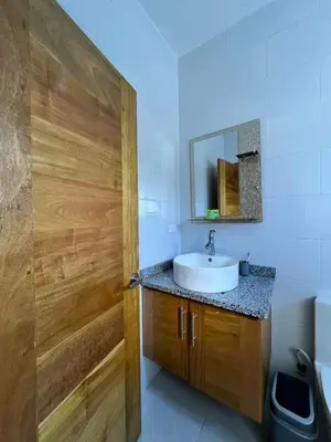a bathroom with a sink and a wooden door at Villa Angel in San Felipe de Puerto Plata