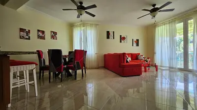 a living room with a red couch and a table at Hispaniola Beach Retreat in Sosúa