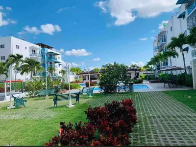 a park with benches and trees and buildings at Harmony II , 5 Min to Airport, Pool View Balcony in Santiago de los Caballeros