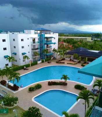 an overhead view of a swimming pool in front of a building at Harmony II , 5 Min to Airport, Pool View Balcony in Santiago de los Caballeros
