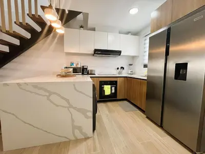 a kitchen with a stainless steel refrigerator and a staircase at Exclusivo penthouse con piscina en Playa Bávaro in Punta Cana