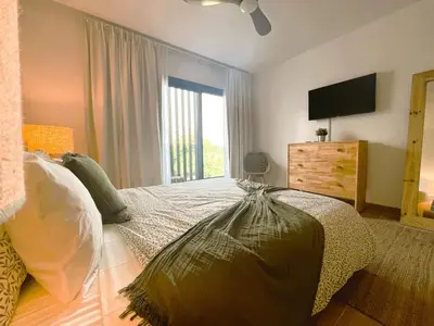 a bedroom with a large bed and a television at Exclusivo penthouse con piscina en Playa Bávaro in Punta Cana