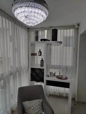 a living room with a chair and a chandelier at El apartamento que tu necesita para disfrutar tu vacaciones in Villa Mella
