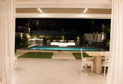 a backyard with a pool and a table and chairs at Villa Antonia Spectacular Private Stay with Pool, Just Steps from the Beach, Housekeeping & Kitchen in Exclusive Gated Community in Las Terrenas