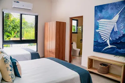a bedroom with two beds and a painting on the wall at Villa Antonia Spectacular Private Stay with Pool, Just Steps from the Beach, Housekeeping & Kitchen in Exclusive Gated Community in Las Terrenas