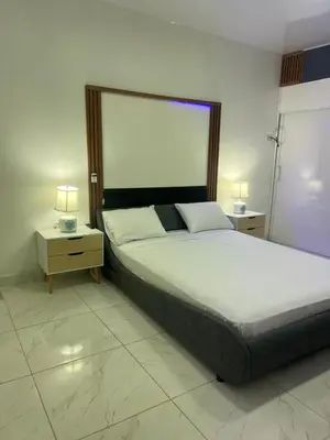 a bedroom with a large bed and two night stands at Bello y acogedor Apartamento in Santiago de los Caballeros