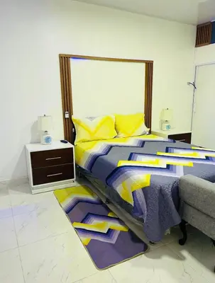 a bedroom with a large bed and a night stand at Bello y acogedor Apartamento in Santiago de los Caballeros